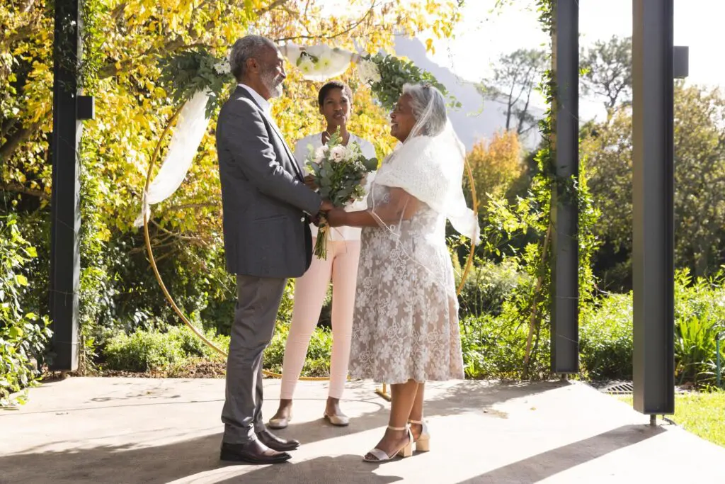 Elderly couple marrying in outdoor ceremony.