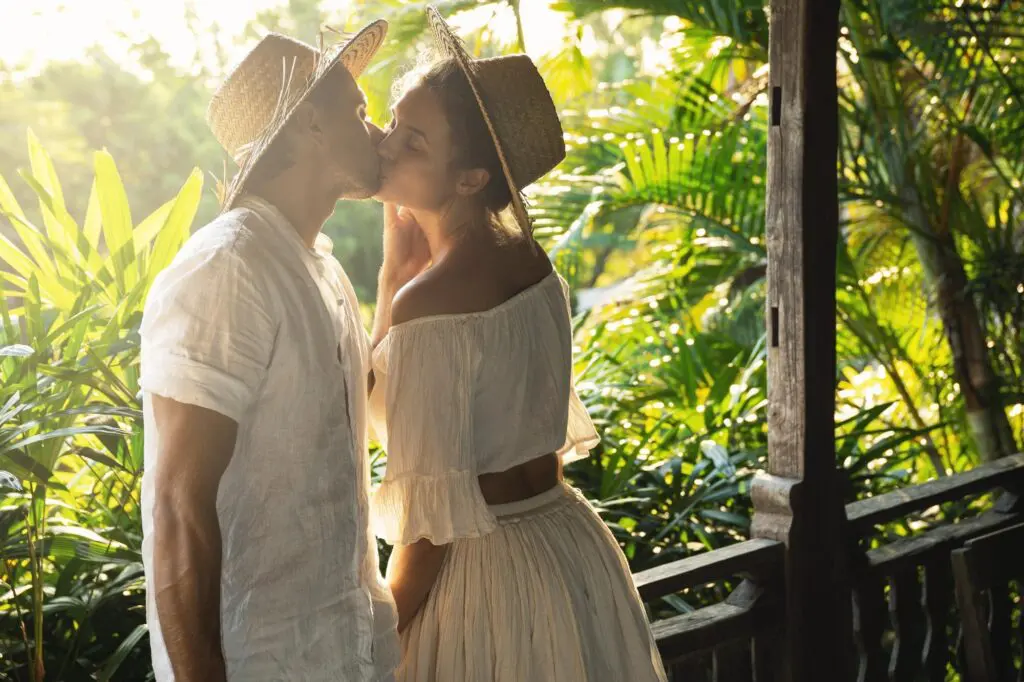 Couple kissing on a tropical porch.