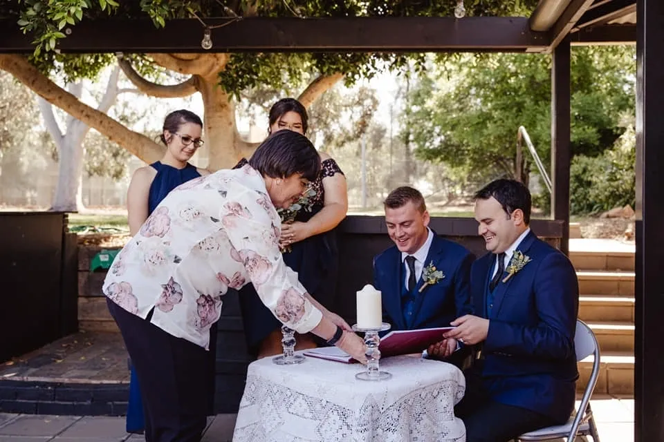 Wedding ceremony with couple signing document.
