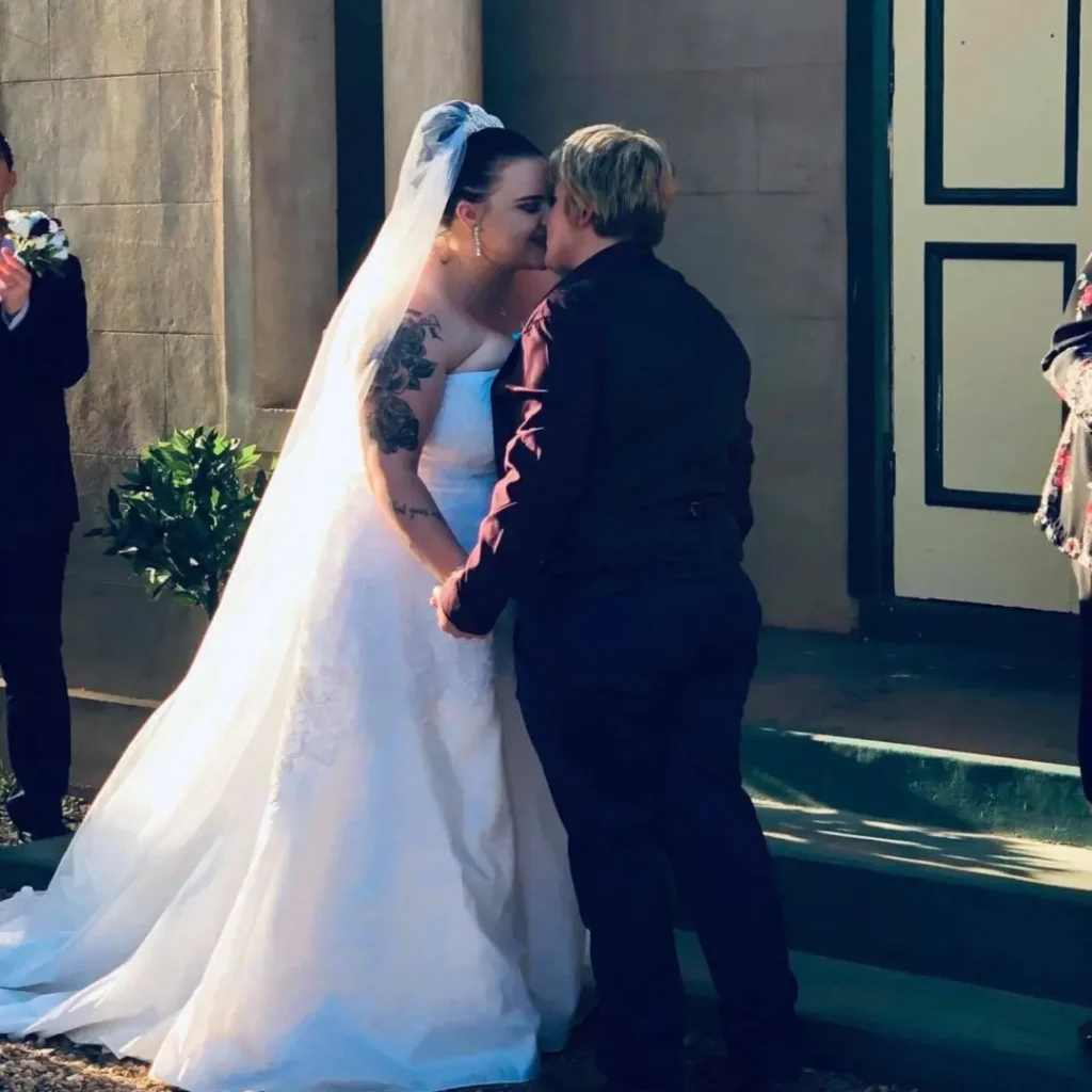 Bride and partner share a wedding kiss.