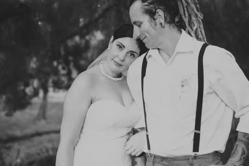Bride and groom embracing in outdoor setting.